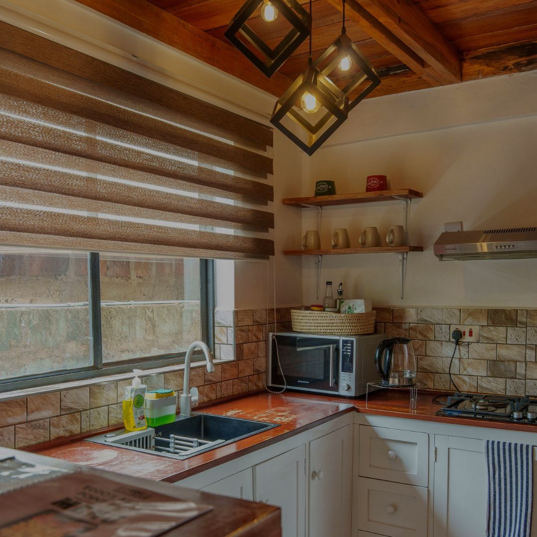 Kitchen with wooden countertops, tiled walls, and modern lighting fixtures.