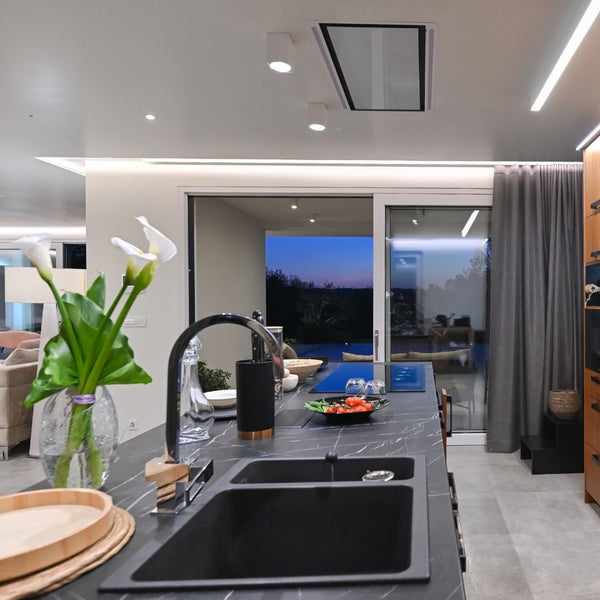 Modern kitchen with black sink and countertop, featuring a view of an outdoor area.