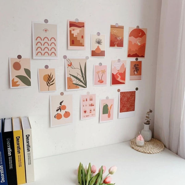 Wall with various small posters and books on a white surface.
